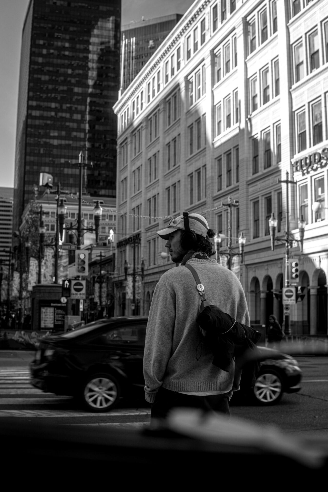 Listener wearing headphones crossing a busy city street