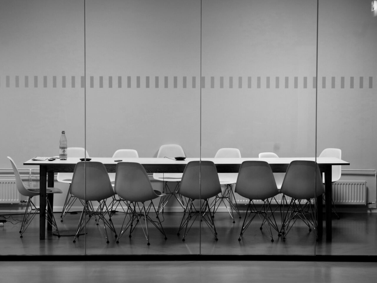 Long meeting table and chairs in a bright, minimal boardroom