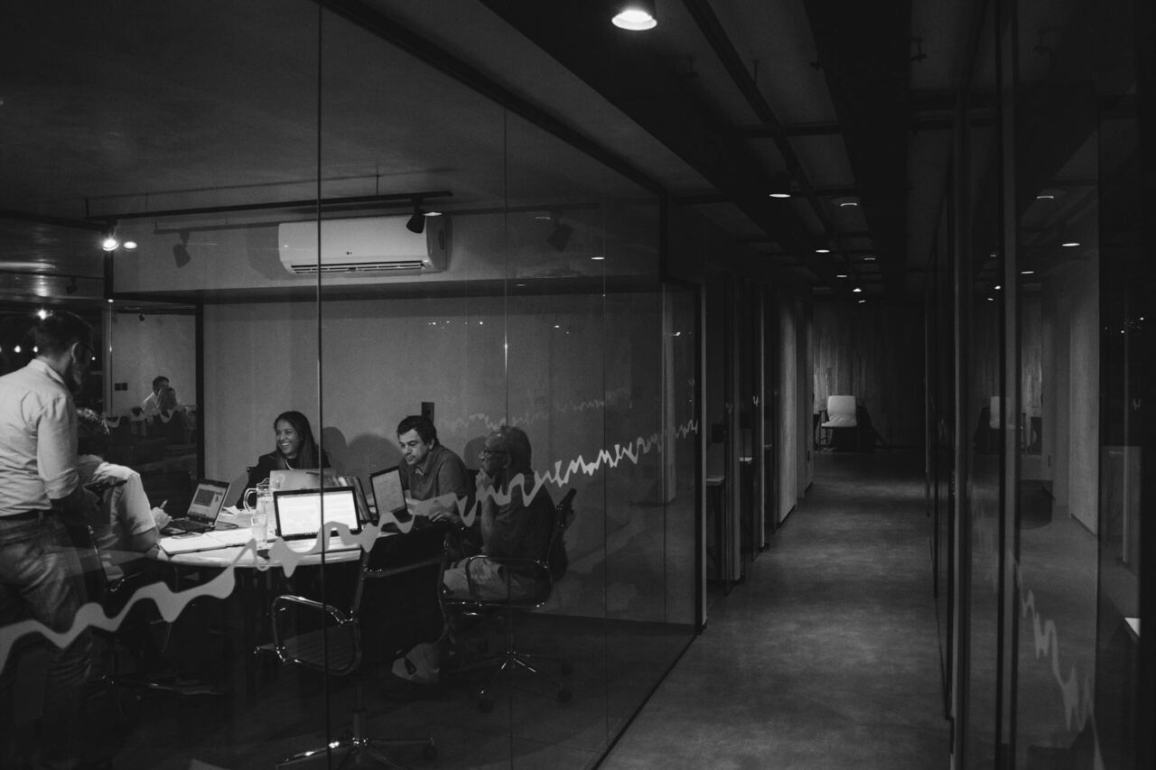 Agency team working together in a darkened open-plan office at night